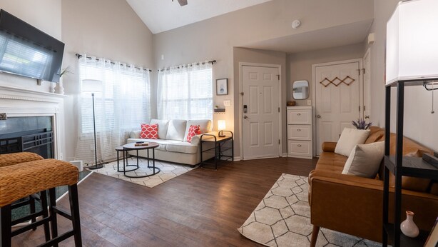 A living room with a fireplace, a sofa, a coffee table, and a ceiling fan.