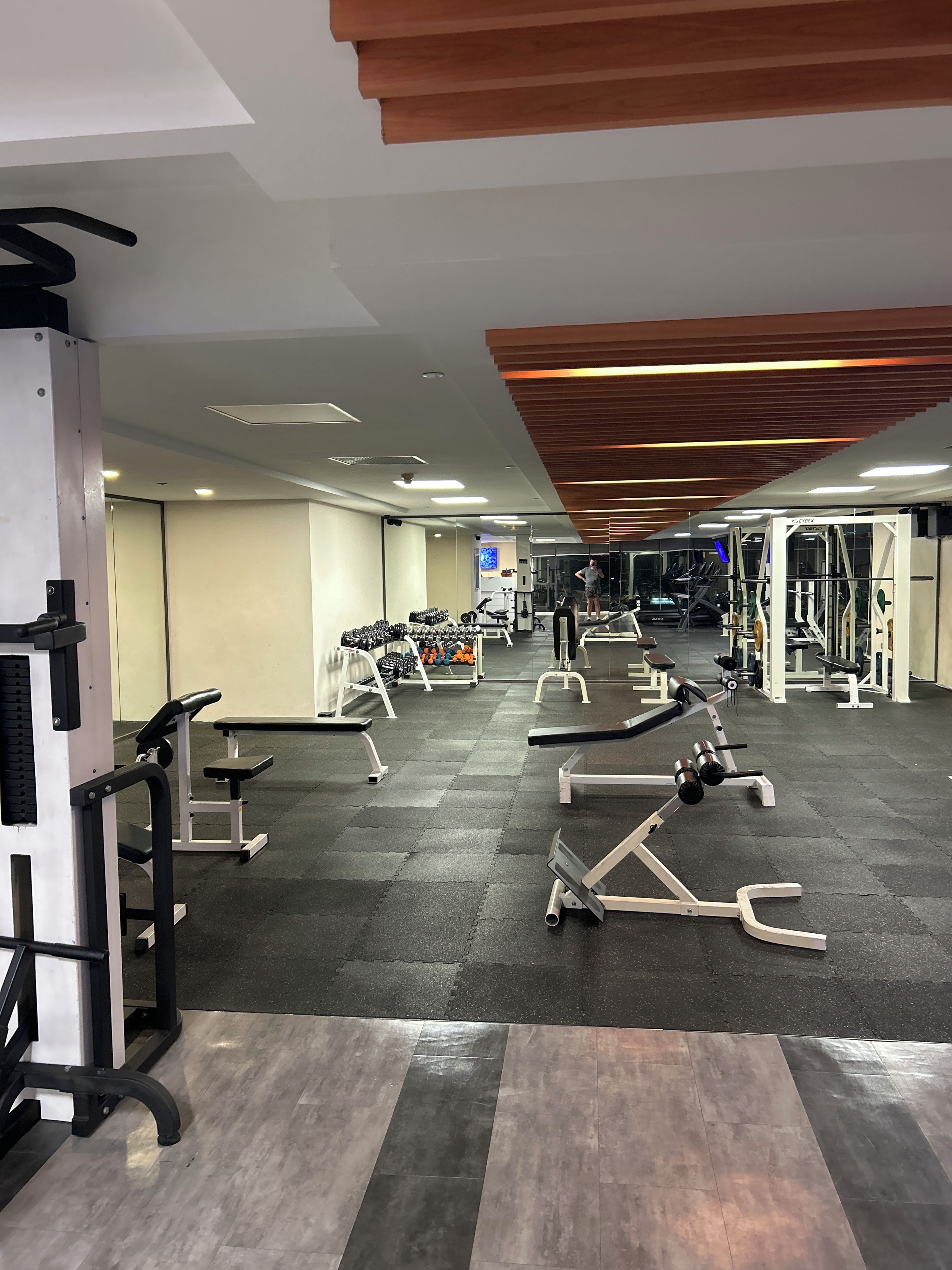 A gym with various exercise equipment, including benches and weight machines.