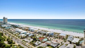A coastal town with a beachfront, buildings, and a road.