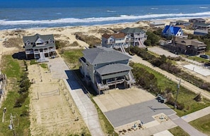 Un área residencial costera con casas, una playa y una vista despejada del océano.