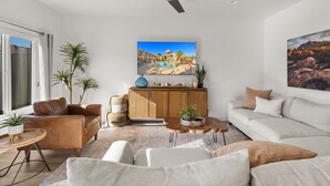 A modern living room with a sofa, coffee table, and a ceiling fan. - 12 The Vues | Resort pool, Private balcony, (Saint George)