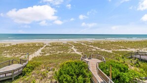 Une plage avec des passerelles en bois et une vue dégagée sur l’océan.