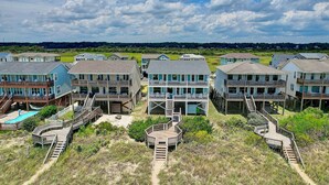Un quartier résidentiel situé sur la côte, composé de plusieurs maisons à deux étages dotées de balcons et de terrasses en bois.