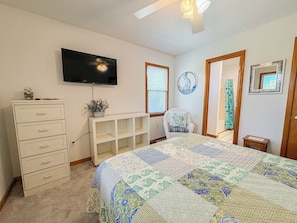 A bedroom with a bed, dresser, TV, and a chair. - House N Duck - Located in the heart of Duck, this 5 BR home is a pleasant walk away from the beach! (Duck)