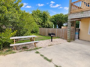 A backyard with a wooden picnic table, a mailbox, and a wooden fence. - House N Duck - Located in the heart of Duck, this 5 BR home is a pleasant walk away from the beach! (Duck)