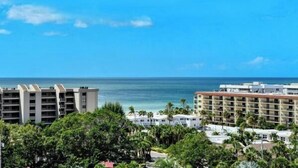 A hotel with multiple floors, a view of the ocean, and lush greenery. - Anchorage PH-2 in Siesta Key, FL (Siesta Key)