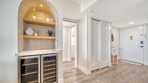 A hallway with a built-in wine cooler, a clock, and a decorative shelf. - Anchorage PH-2 in Siesta Key, FL (Siesta Key)