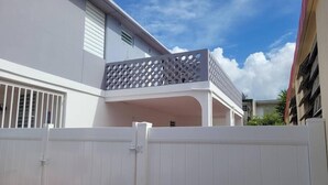 A white building with a balcony featuring a lattice design. - Sunset Private Studio (Toa Baja)