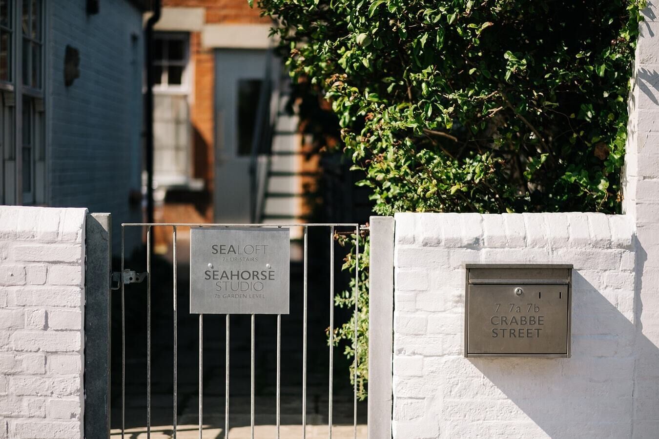 Une grille métallique avec une enseigne indiquant « SEAHORSE STUDIO », située au septième niveau du jardin.