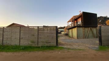 A fenced property with a wooden building featuring a balcony.