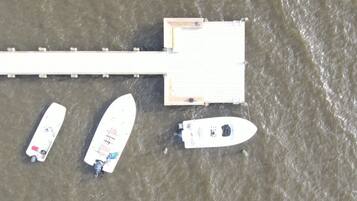An aerial view of a dock with three boats moored alongside.