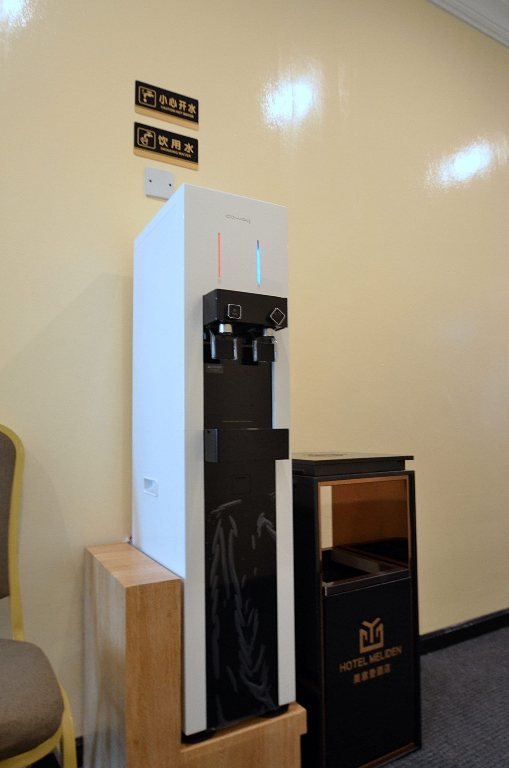Un dispensador de agua y un cubo de basura en una habitación de hotel.