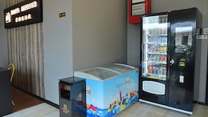 A hotel lobby with a large ice cream freezer, a vending machine, and a sign indicating the hotel name. - Hotel Meliden (Sandakan)
