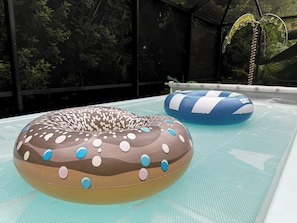 An indoor swimming pool with two inflatable donut-shaped floats.