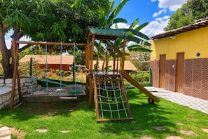 Ein Spielplatz mit Schaukeln und einer Kletterkonstruktion.