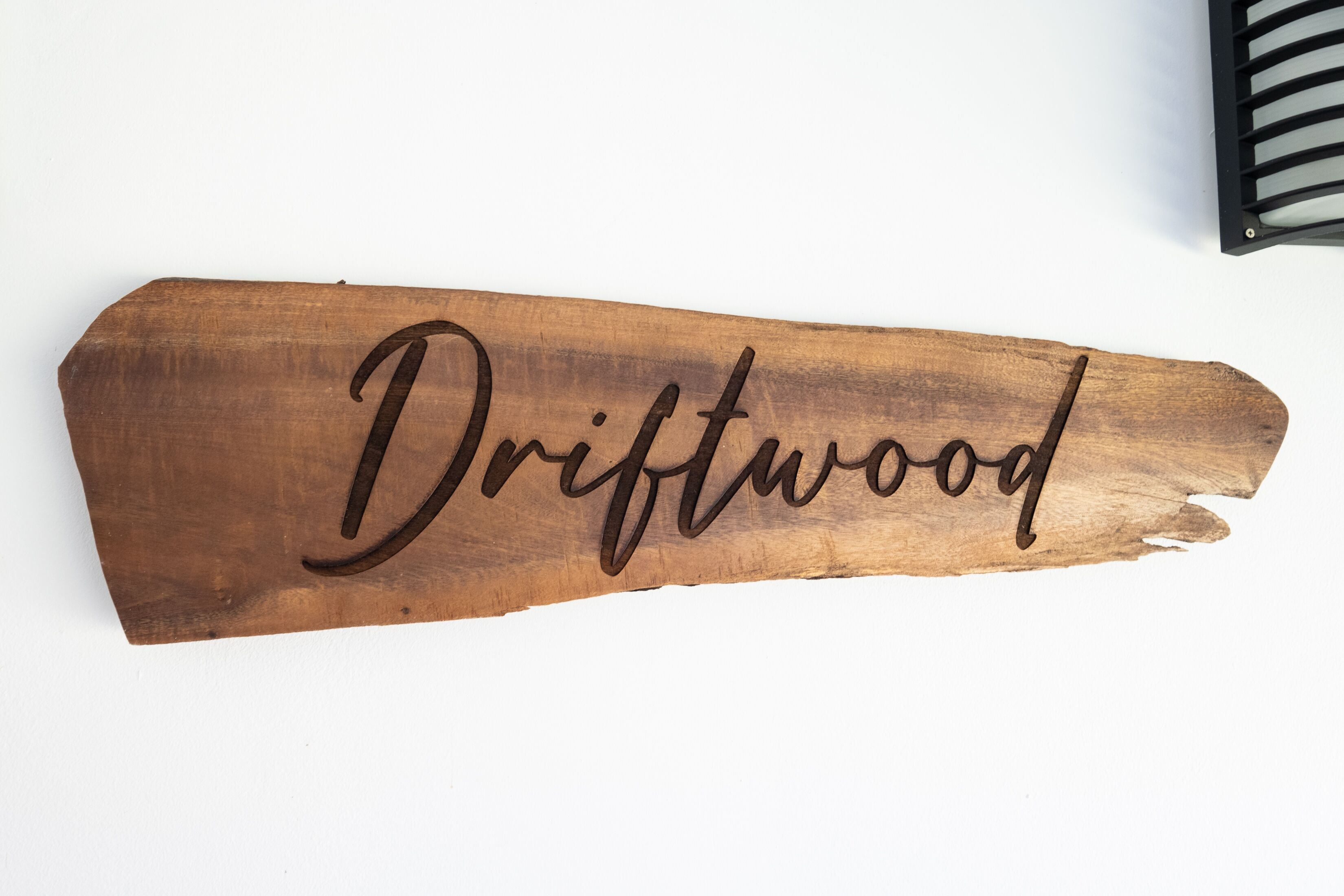 Un cartello di legno con la scritta "Driftwood" intagliata.
