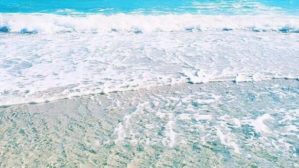 Ein Strand mit klarem türkisblauem Wasser und weißem Sand.