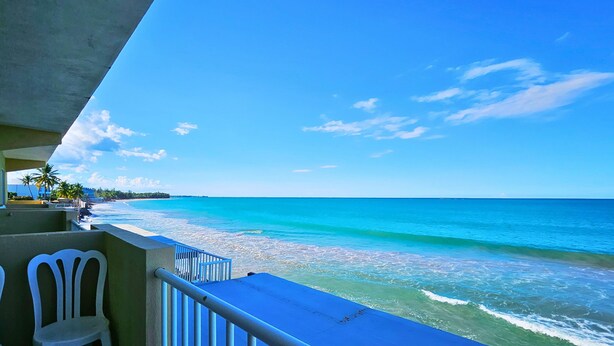 Ein Balkon mit Blick auf Strand und Meer.