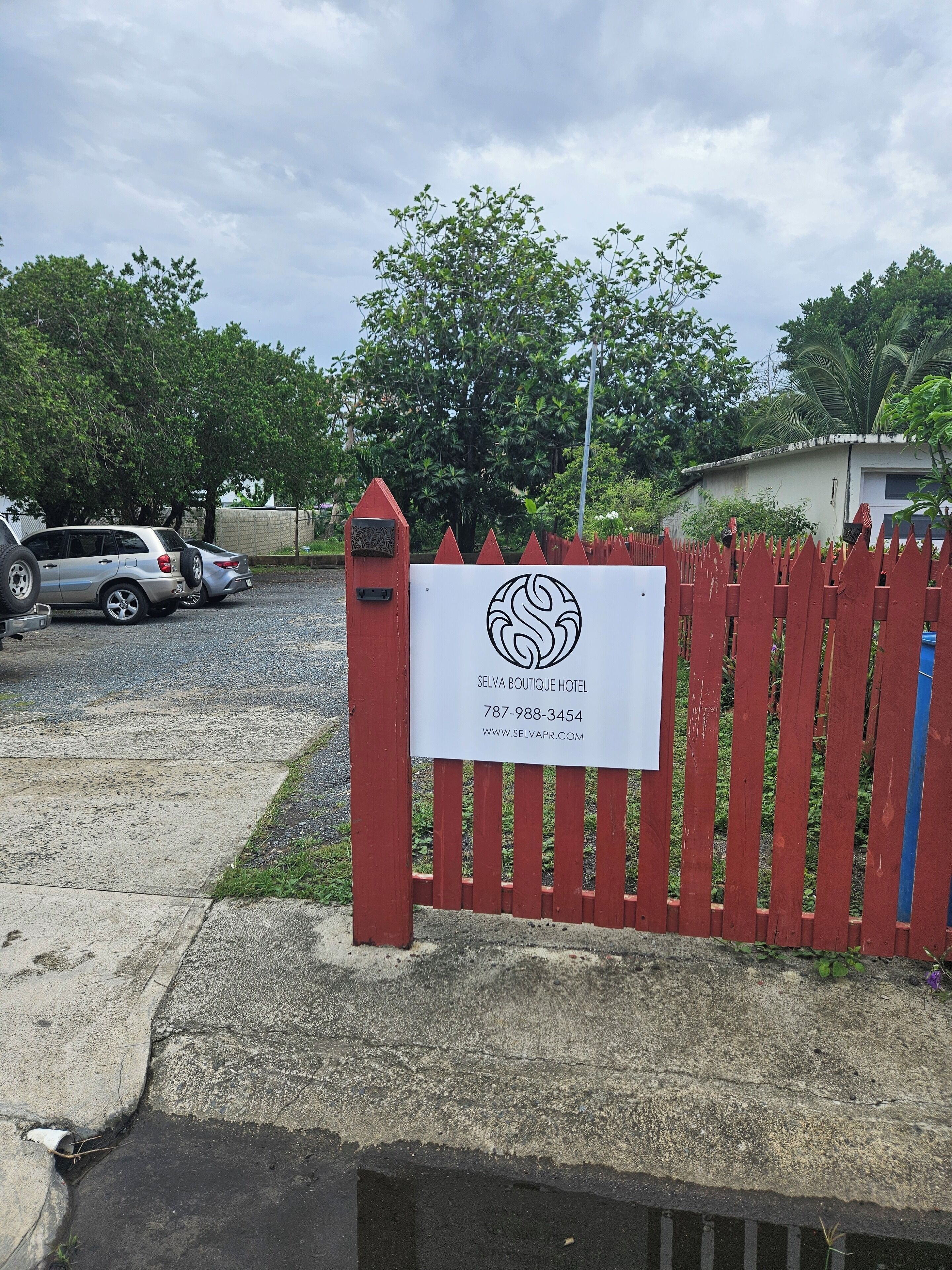 Una entrada de hotel con un cartel de Selva Boutique Hotel, que incluye información de contacto y sitio web.