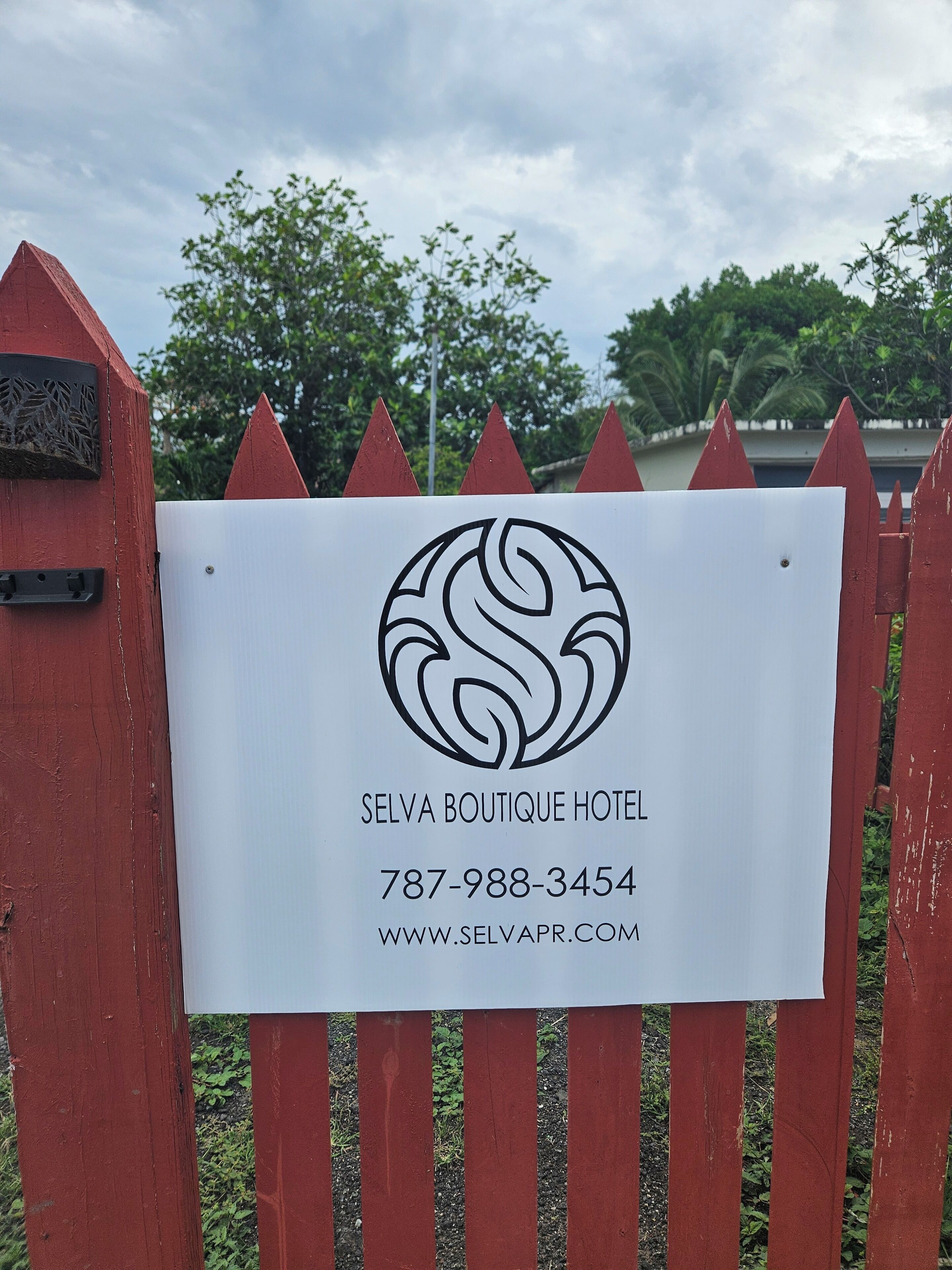 A sign for Selva Boutique Hotel with contact information and a website URL.