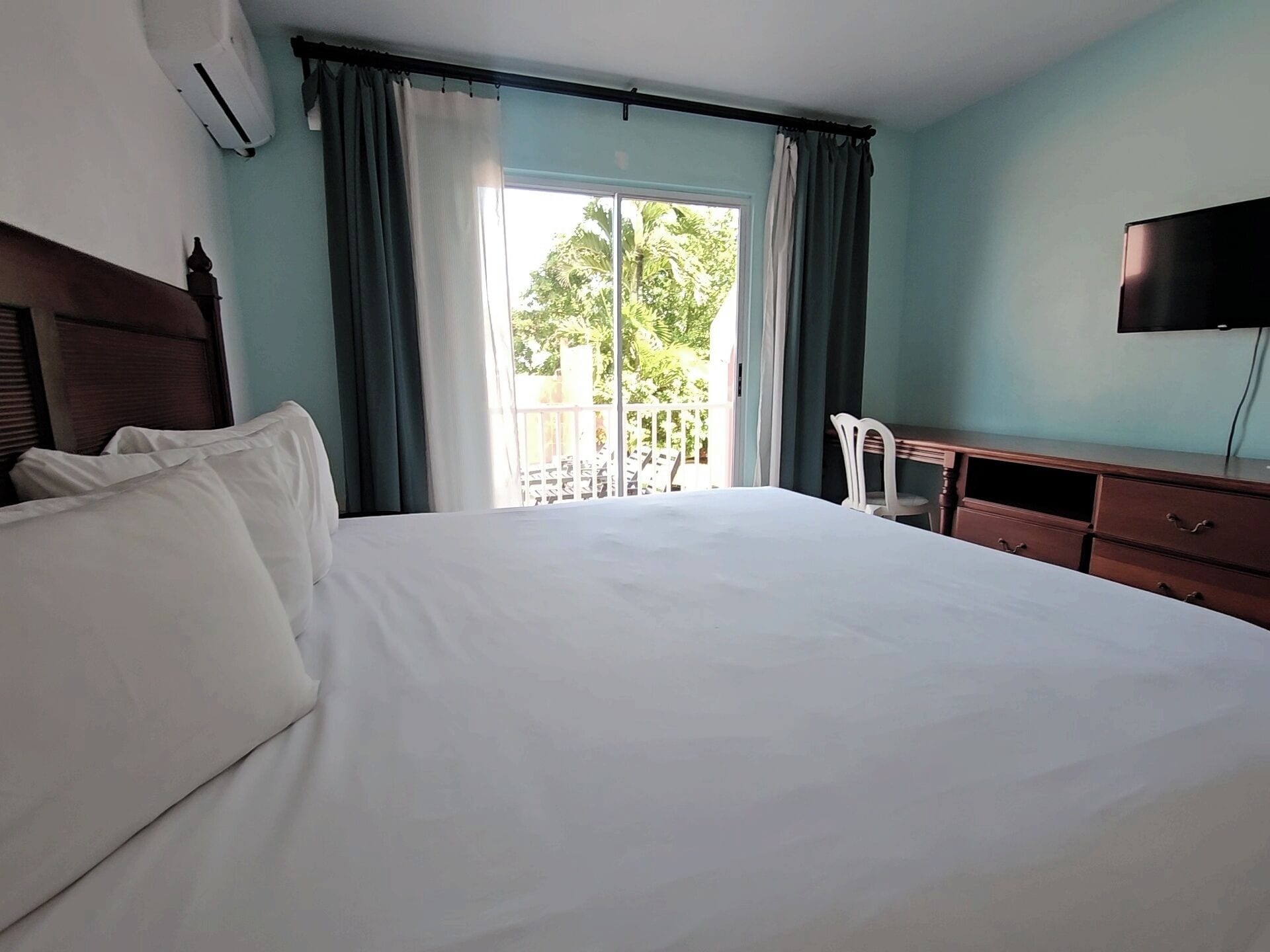 Een hotelkamer met een groot bed, een bureau, een stoel en een televisie.