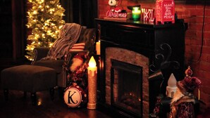 A cozy room with a brick wall, a Christmas tree, a fireplace, and a flat-screen TV mounted above it. - 1800s Victorian Loft  (Concord)