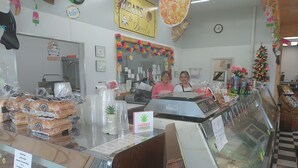 A deli counter with various packaged meats and hot dogs, a cash register, and a glass display case with more items. - 1800s Victorian Loft  (Concord)