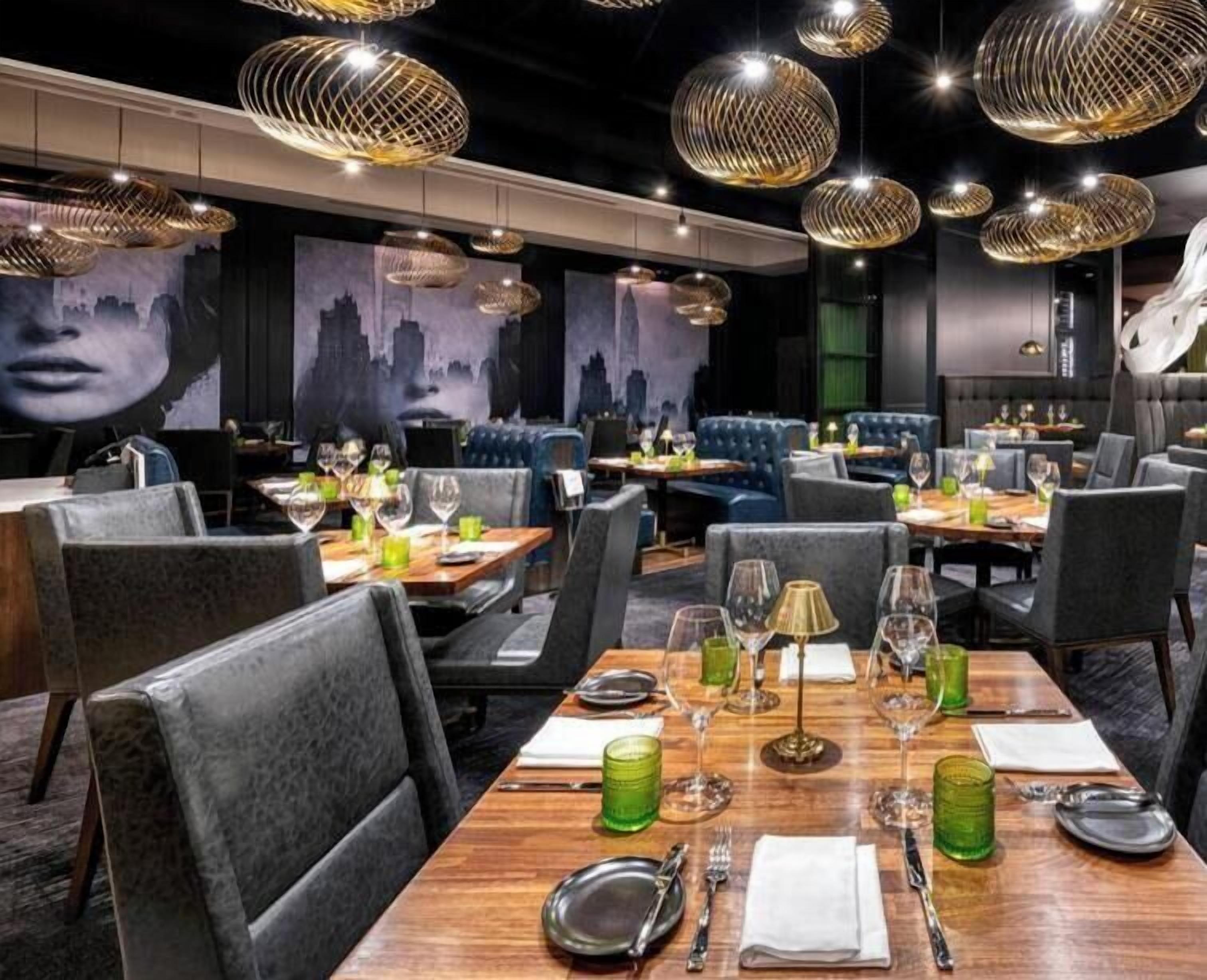Modern dining area with artistic wall murals and unique pendant lighting.