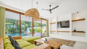 Un salon moderne avec un canapé, une table basse en bois et un téléviseur.