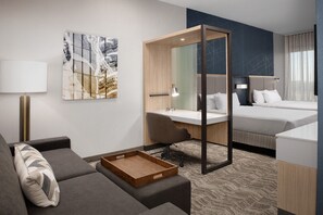 A modern hotel room with a sofa, desk, and bed. - Springhill Suites By Marriott Fayetteville I 95 (Fayetteville)