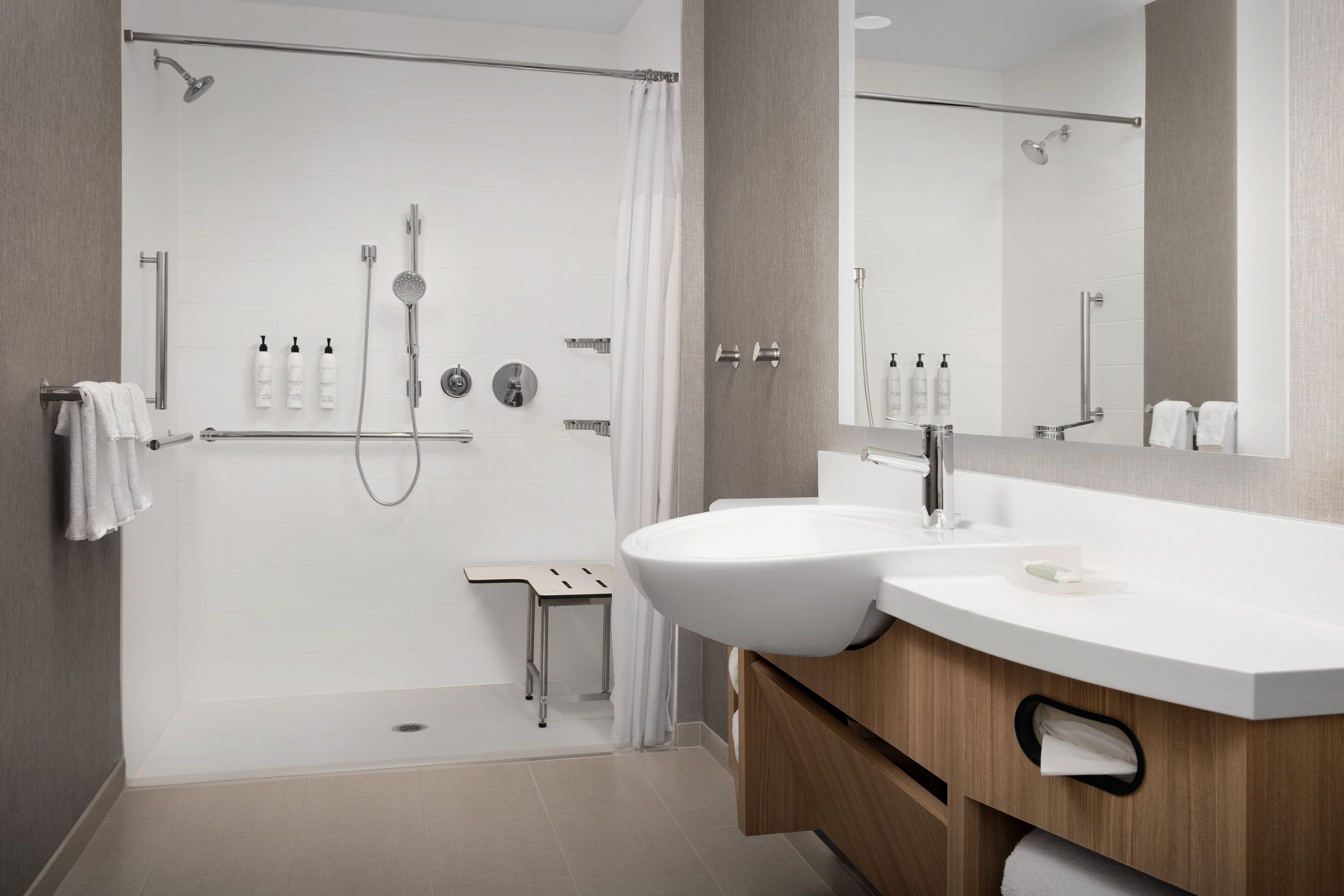 A modern bathroom with a shower, a sink, and a mirror.