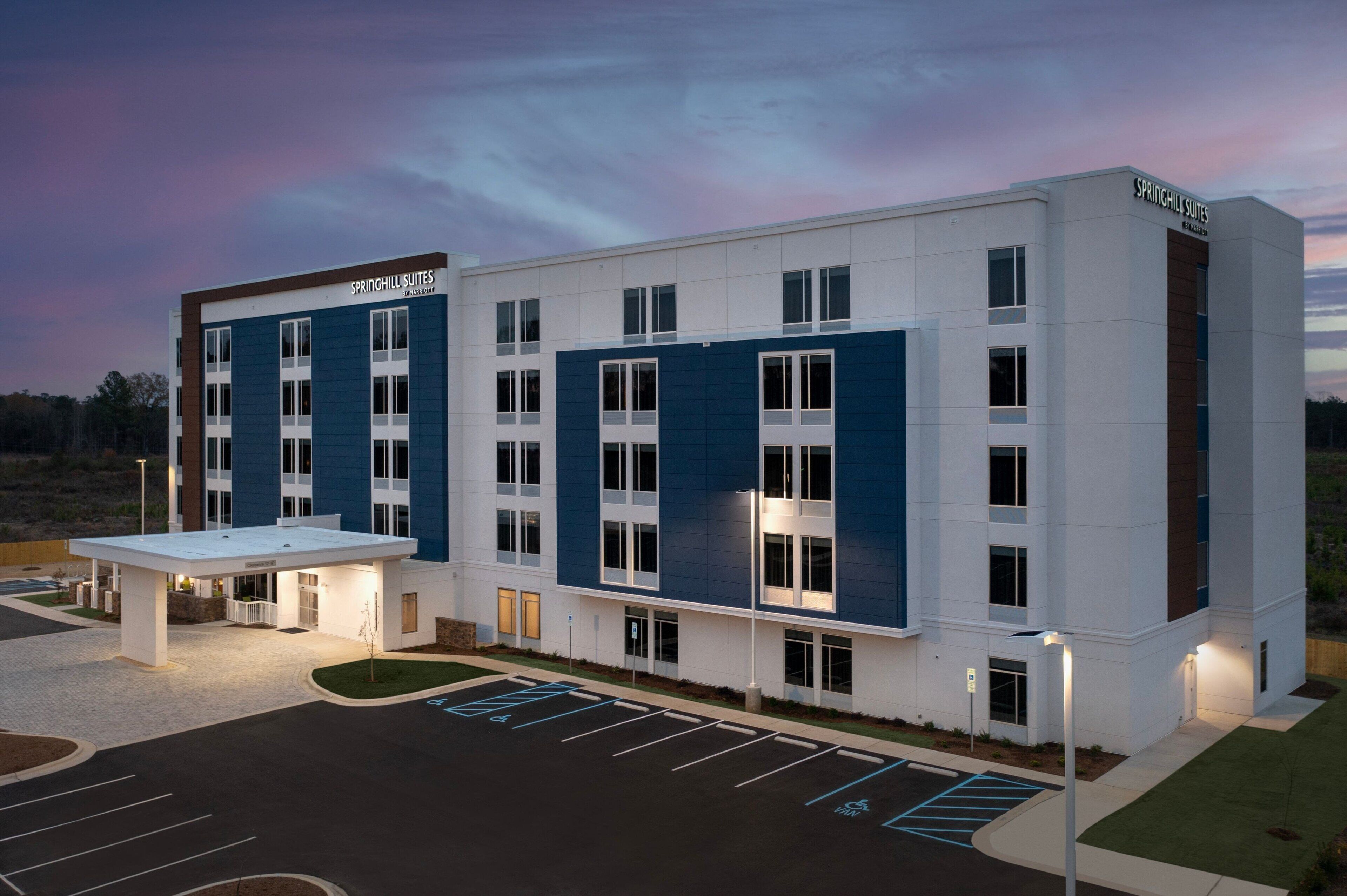 Un hotel moderno con techo plano, amplias ventanas y zona de acceso cubierta.