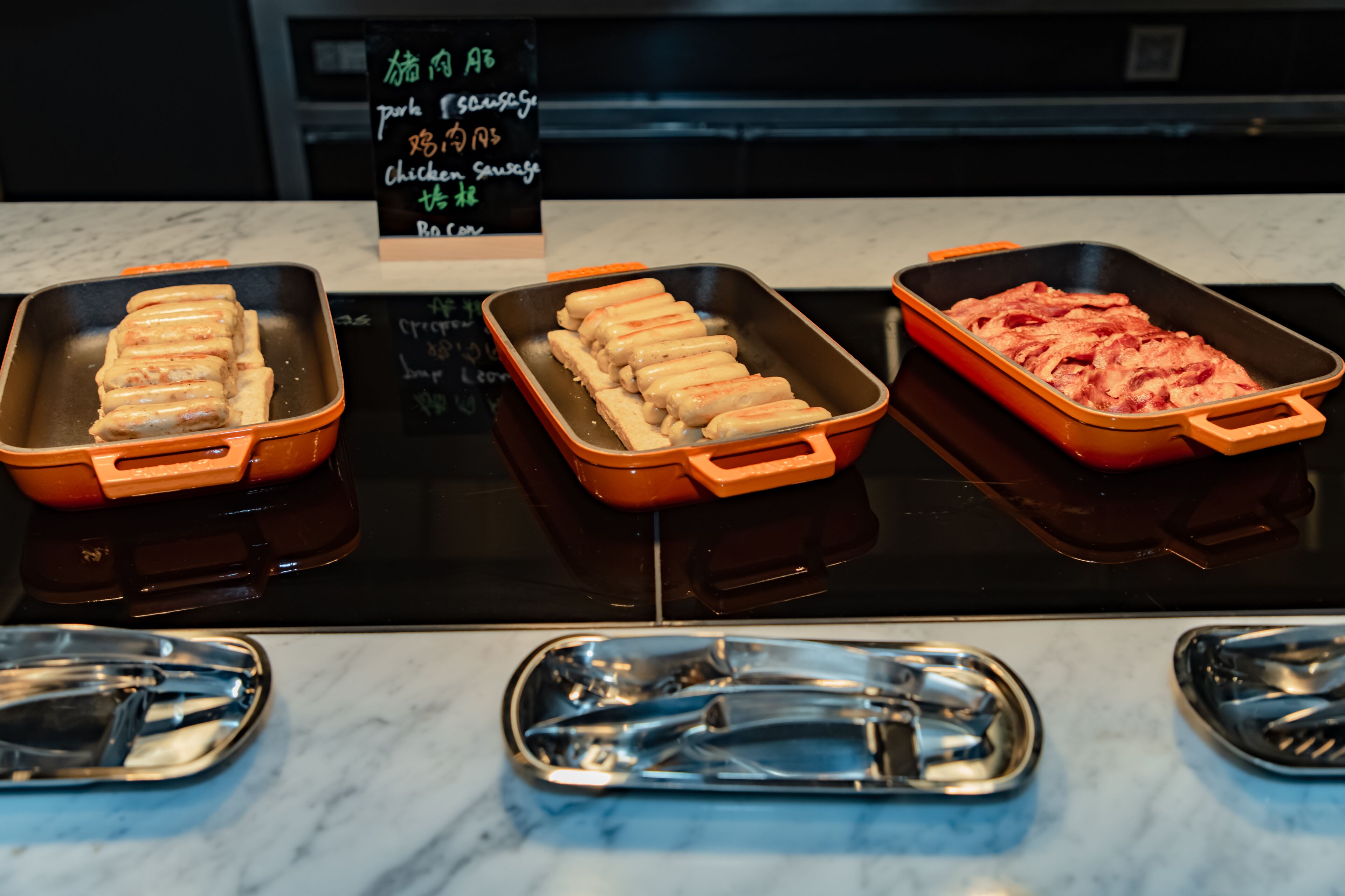 Três bandejas com alimentos sobre uma bancada de cozinha.