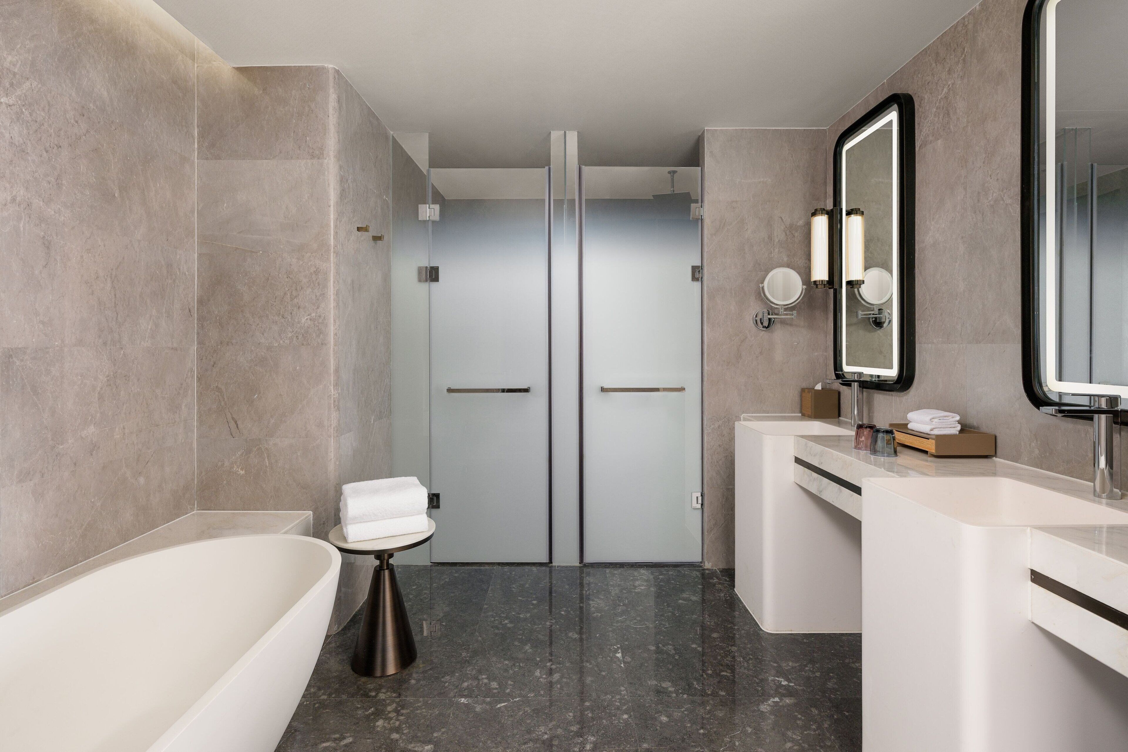 A modern bathroom with a bathtub, a shower, and a vanity with a mirror.
