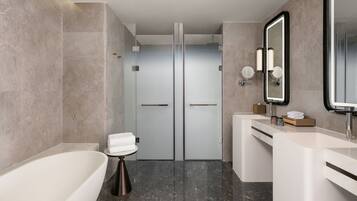 A modern bathroom with a bathtub, a shower, and a vanity with a mirror.