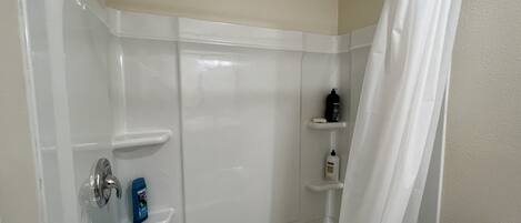 Un baño moderno con ducha, inodoro y lavamanos.