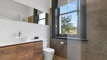 Ein modernes Badezimmer mit einem weißen Waschbecken, einer Toilette und einem großen Spiegel.