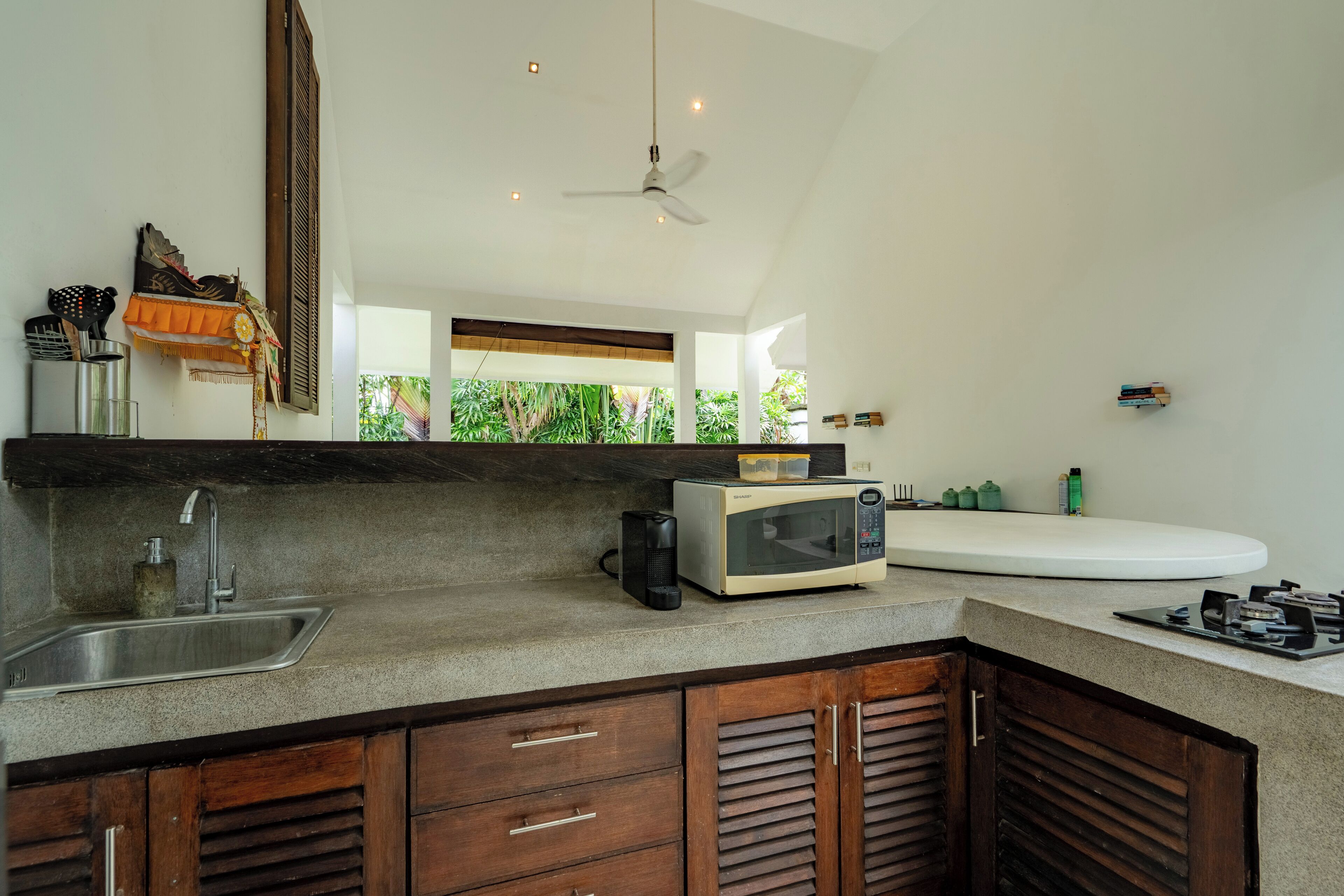 Una cucina moderna con forno a microonde integrato, lavello e pensili in legno.