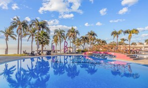 A swimming pool with lounge chairs and palm trees, surrounded by a wooden bridge and a large 'B' structure. - Villa 21: Private Rooftop Pool & BNayar Beach Club (Cruz de Huanacaxtle)