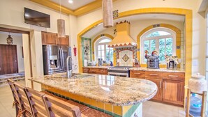 A spacious kitchen with a granite countertop, stainless steel appliances, and a large island.