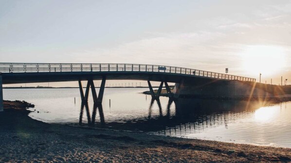 A bridge over calm water with a clear sky.