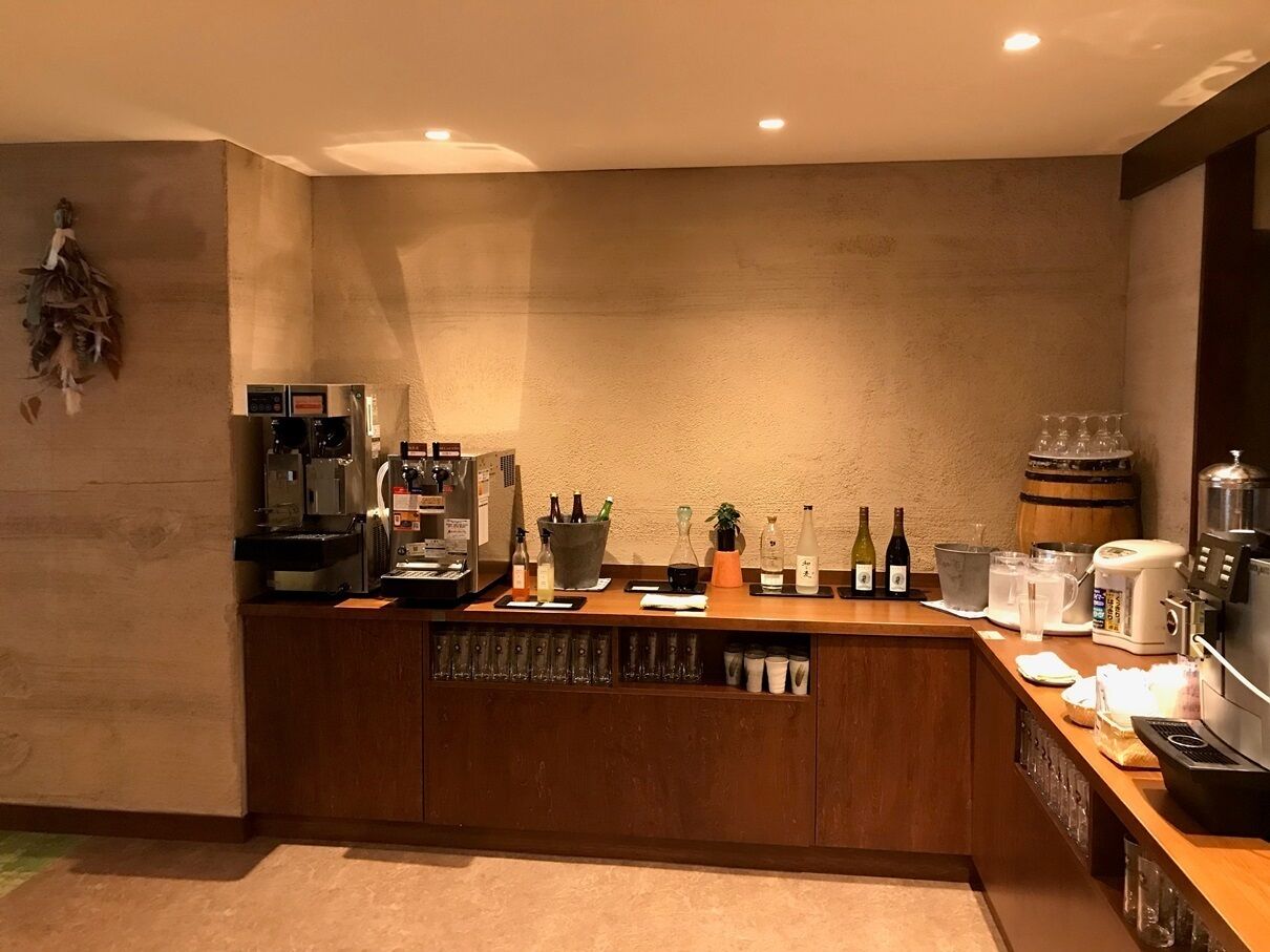 Uma cozinha moderna com bancada de madeira, cafeteira, garrafas de vinho e prensa de café.