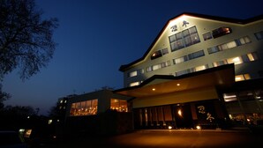Een hotel met meerdere verdiepingen, verlichte signage en een modern architectonisch ontwerp.