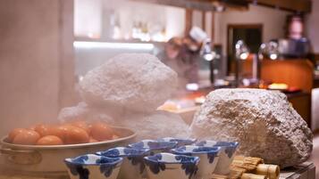 A traditional Japanese tea ceremony setup with a teapot, cups, and a large rock.