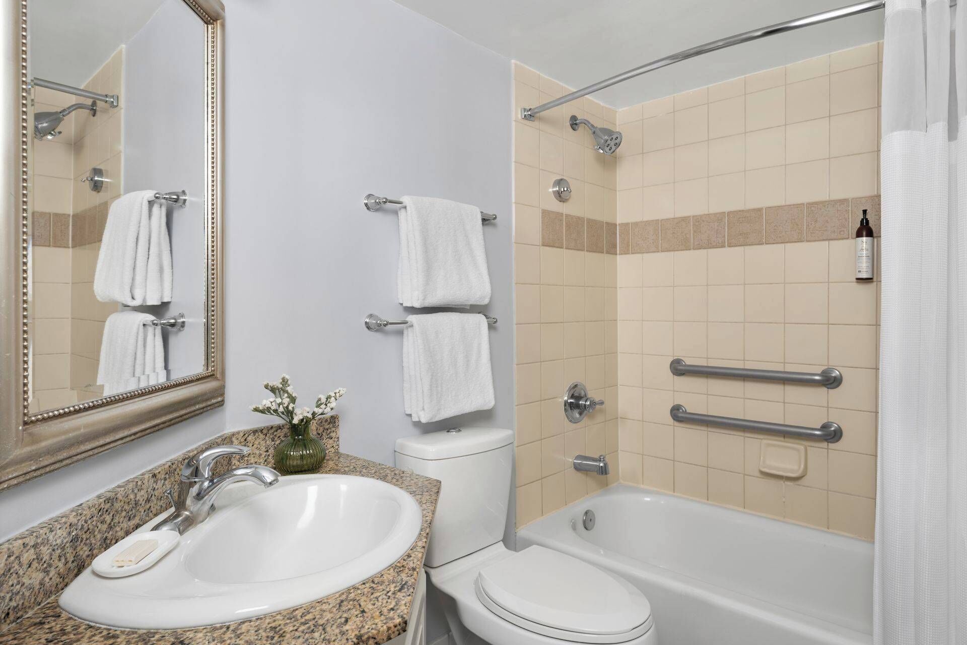 Une salle de bain équipée d’un lavabo, de toilettes, d’une baignoire et d’une douche.
