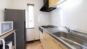A modern kitchen with a stainless steel sink, a microwave, and a stove. - Yotei Chalets (Niseko)