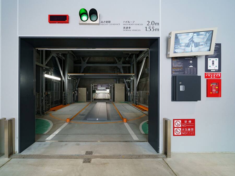 Ein Fahrzeugdurchgang mit Durchfahrtshöhenanzeigen, Brandmelder und Überwachungskamera.