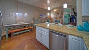 Una cocina con armarios blancos, encimera de granito y lavavajillas empotrado.
