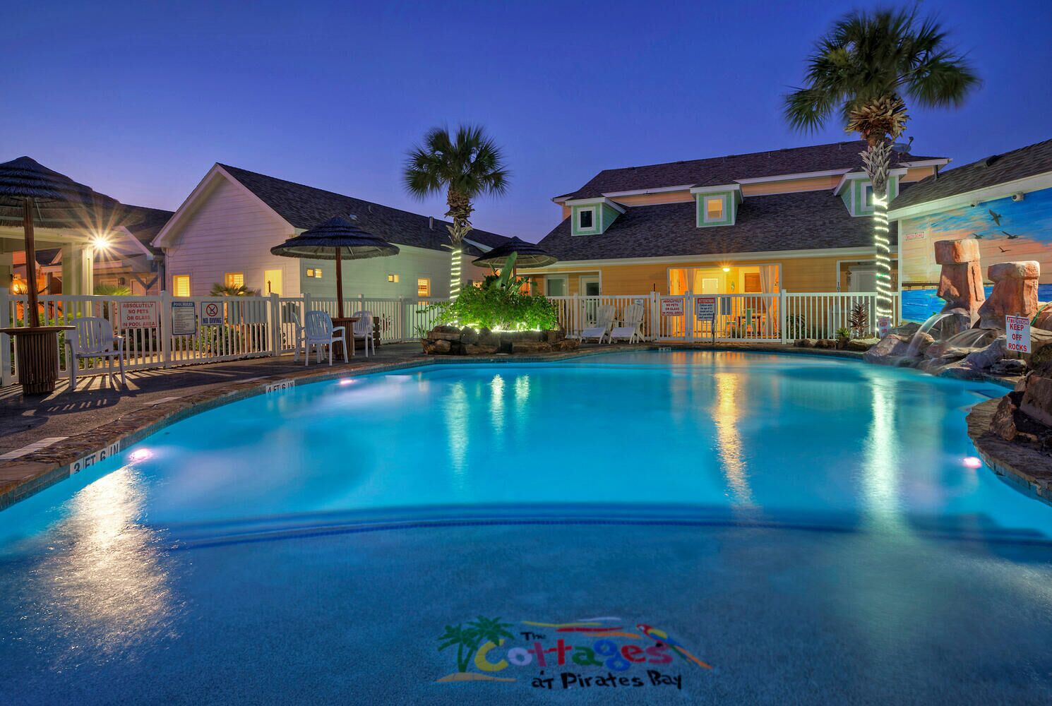 Una piscina con un letrero que dice "The Cottages at Pirates Bay".
