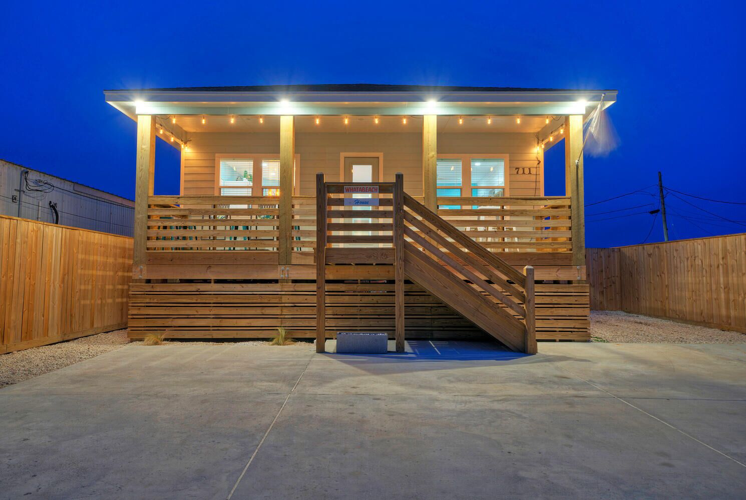 A wooden cabin with a staircase, a covered porch, and a sign that reads "Whatabeggin."